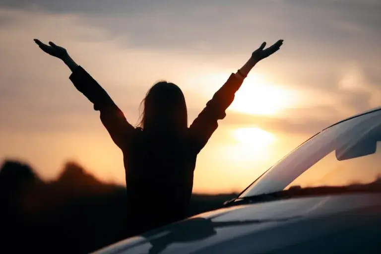 Silhouette of Happy Female Driver Next to her Car